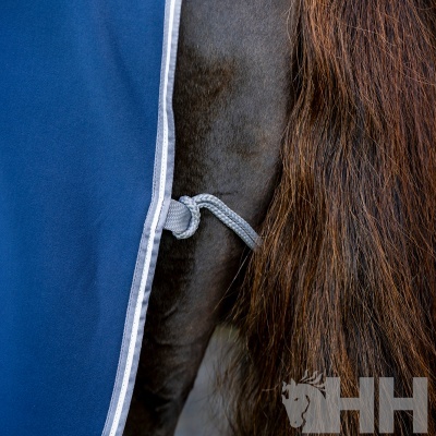 Manta azul e branca para cavalo com fintas de corda cinzenta e pelo castanho e preto