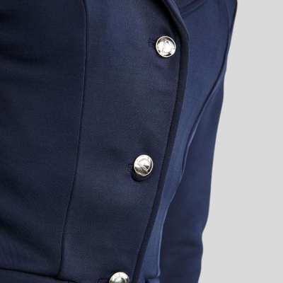 Blazer azul escuro com botões prateados e bolso com aba em fundo cinza claro