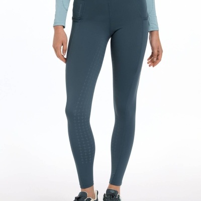 Leggings azul escuro com bolsos e detalhes perfurados usadas com ténis e t-shirt azul clara