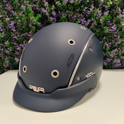 Capacete de proteção azul escuro Casco com detalhes metálicos sobre superfície branca