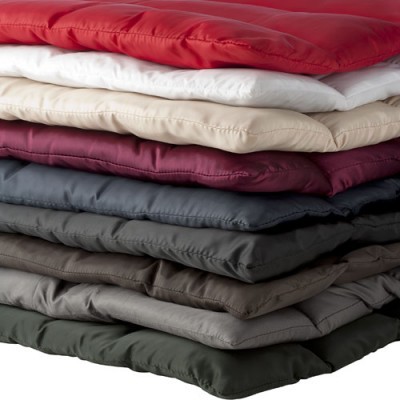 Pilhas de almofadas acolchoadas para cadeiras em várias cores sólidas.