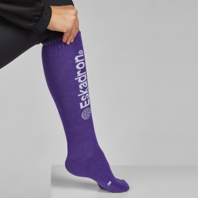 Meia longa roxa com inscrição Eskadron em branco usada numa perna