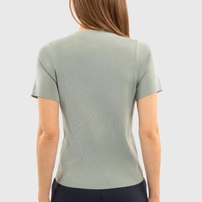 Camisola cinza claro de manga curta vista de costas em mulher com calças pretas