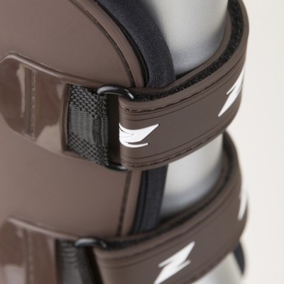 Bota ortopédica castanha com alças de fixação e velcro numa perna de manequim prateado