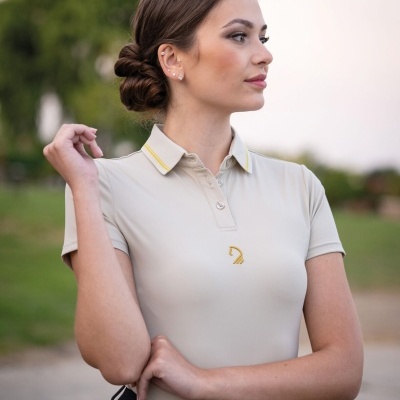 Mulher com polo bege e calças pretas ao ar livre