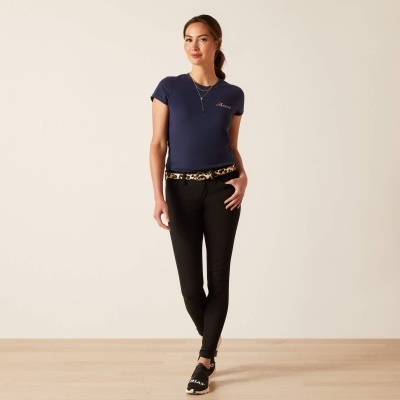 Mulher com t-shirt azul, calças pretas e cinto com padrão animal em fundo branco