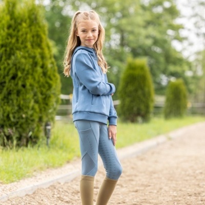 Menina com casaco azul e calças justas azuis em caminho de terra outdoors