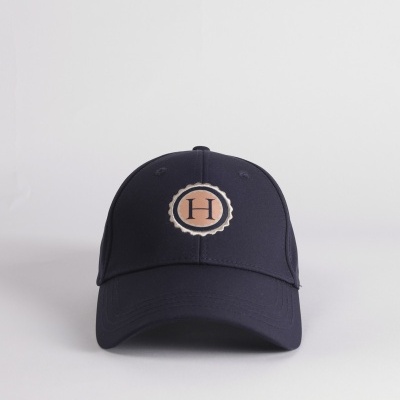 Boné de basebol preto com emblema circular bege e castanho com letra H