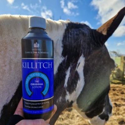 Frasco de loção KILLITCH com cavalo preto e branco ao fundo