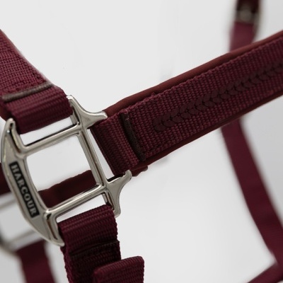 Cabeçada de cavalo em nylon bordô com fivelas metálicas e inscrição HARCOUR.