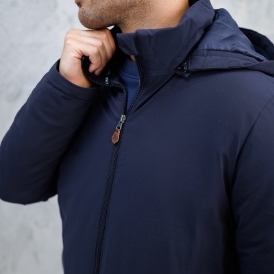 Homem com casaco azul escuro com capuz e fecho de correr