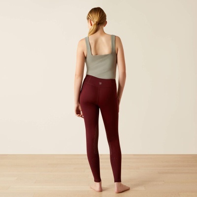 Modelo de costas a vestir calças legging vinho com padrão de reforço e top cinza