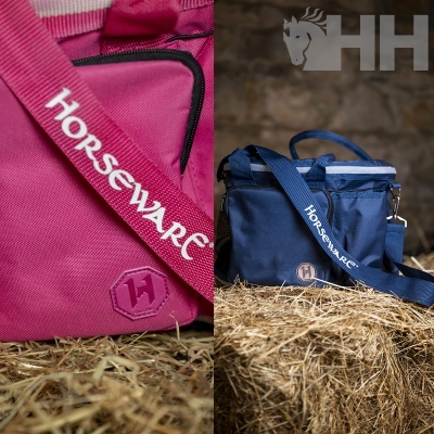 Bolsas de tecido rosa e azul com alças 'Horseware' sobre feno, logo HH no fundo.