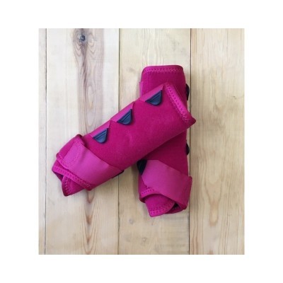 Suportes de pulso rosa com fecho de velcro e detalhes pretos sobre madeira clara