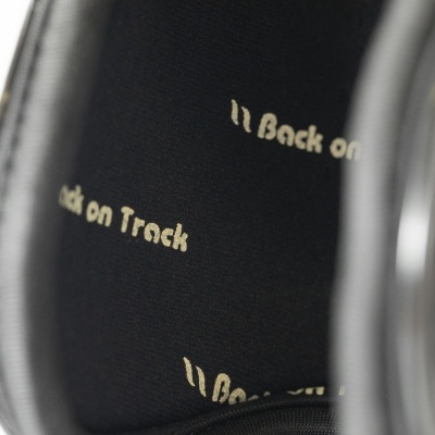 Interior dos auscultadores pretos com texto 'Back on Track'