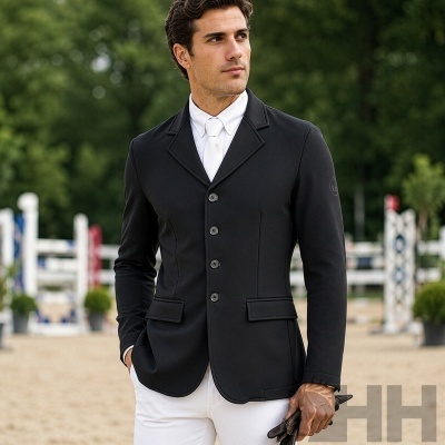 Homem a usar blazer preto com camisa e gravata branca, em arena de equitação.