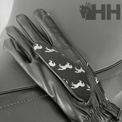 Luvas pretas com padrão de cavalos brancos sobre superfície escura