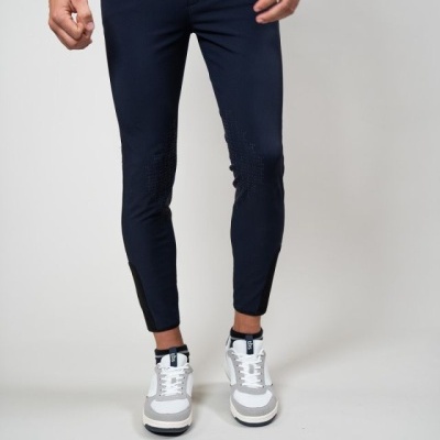 Calças justas azuis escuras com detalhes pretos e sapatilhas brancas e cinzentas