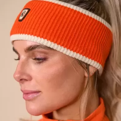 Faixa de cabeça de malha laranja com bordas brancas e logótipo CD usada por mulher com camisola laranja