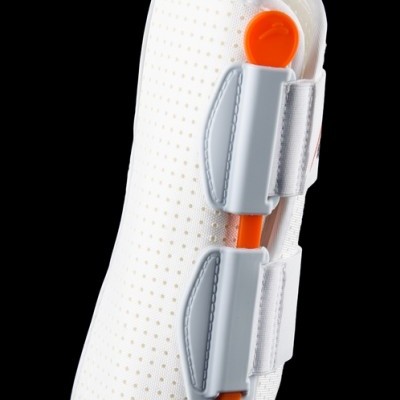 Órtese branca perfurada com suporte cinzento e peça laranja de ajuste