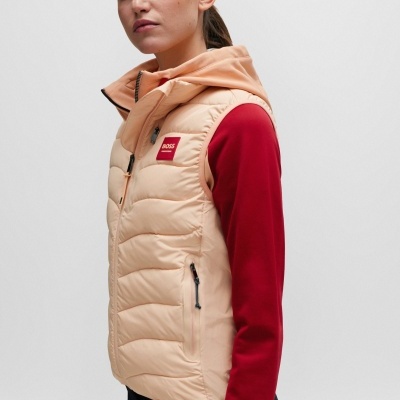 Colete acolchoado bege com capuz e logótipo BOSS, usado sobre camisola vermelha