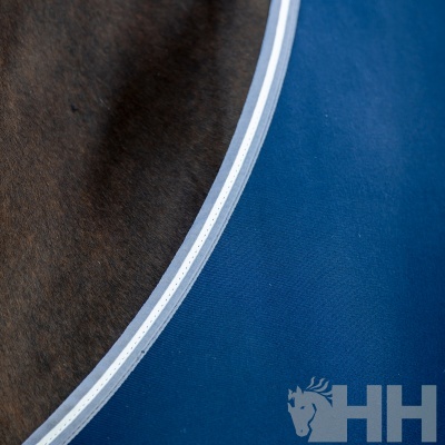 Superfície azul em lona com borda branca e pelo castanho com logótipo de cavalo e letras HH
