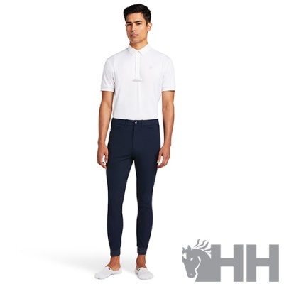 Homem com camisa polo branca, calças azuis escuras e sapatos brancos num fundo branco com logótipo HH