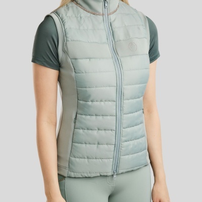 Colete feminino matelassê verde água com zíper e gola alta, usado com t-shirt manga curta verde musgo e leggings verde água.