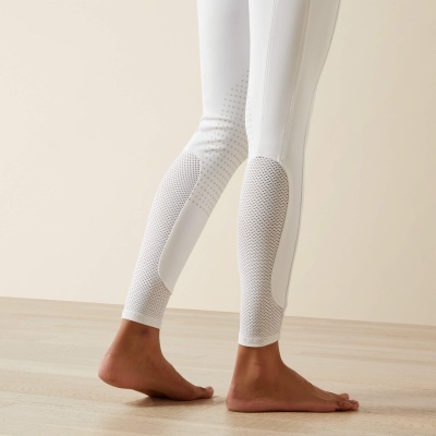 Leggings brancas com detalhes perfurados na panturrilha em ambiente neutro