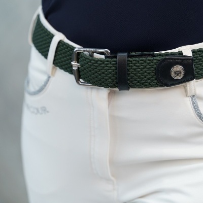 Cinto têxtil verde com fivela de metal usado em calças brancas e top azul escuro