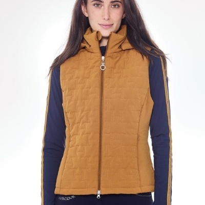 Colete castanho mostarda acolchoado com padrão quadrado, gola alta e fecho metálico, usado sobre t-shirt azul escura com riscas amarelas nas mangas