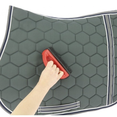 Tapete para cavalo verde com padrão hexagonal e escova vermelha.