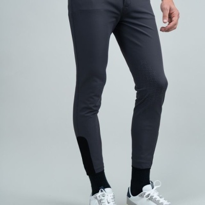 Calças cinzentas escuras HARCOUR usadas com sapatilhas brancas e cinzentas e meias pretas