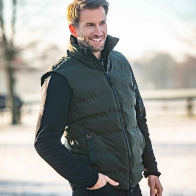 Homem de casaco acolchoado verde escuro e camisa preta ao ar livre