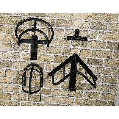 Suportes de parede de metal preto em três formatos diferentes na parede de tijolos claros.
