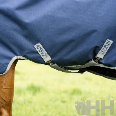 Manta azul para cavalo com tiras AMIGO® e cavalo castanho ao fundo