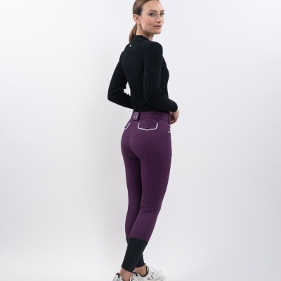 Mulher de costas com calças legging roxas e top preto em fundo branco