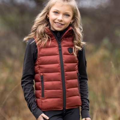 Menina com colete acolchoado vermelho e roupa preta em ambiente exterior