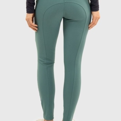 Calças justas verdes femininas vistas de trás com bolsos e ténis brancos