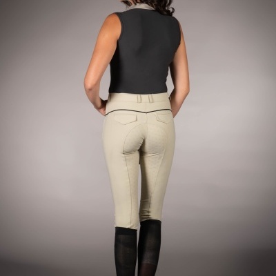 Calças de equitação bege com detalhe preto na cintura e zona antiderrapante usadas com botas pretas