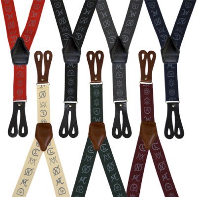 Seis suspensórios coloridos com padrões de símbolos e letras, detalhes em couro castanho e terminais pretos.