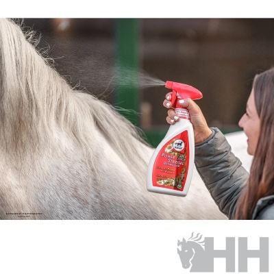 Pulverizador branco com punho vermelho para desembaraçar crinas de cavalos sendo usado numa crina cinzento claro