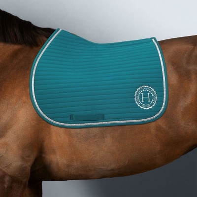 Sela azul turquesa acolchoada com logotipo HARAS LUCCA em cavalo castanho