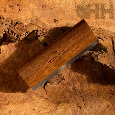 Pente de madeira castanha com marca gravada sobre superfície de madeira natural