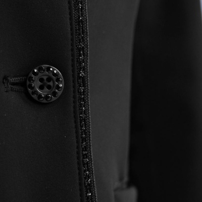 Roupa preta com botão decorativo preto e costura decorativa