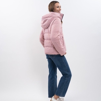 Modelo de casaco rosa acolchoado com capuz, jeans azuis e sapatilhas brancas