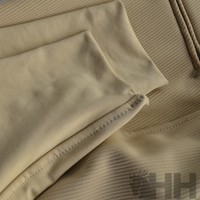 Tecido bege com textura canelada e costura visível, etiqueta 