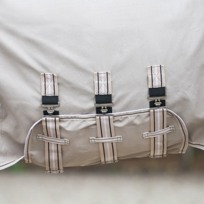 Capa de tecido bege para cavalo com tiras riscas e fechos de metal