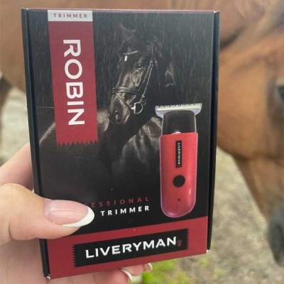 Embalagem preta e vermelha de aparador de pêlos profissional com texto e imagem de um cavalo preto.
