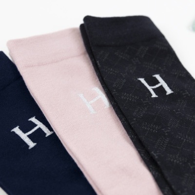 Três pares de meias nas cores azul escuro, rosa claro e preto com letra H bordada